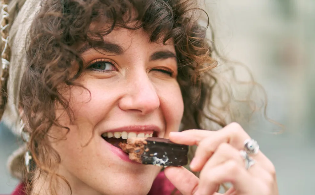 Portrait of happy woman eating chocolate
